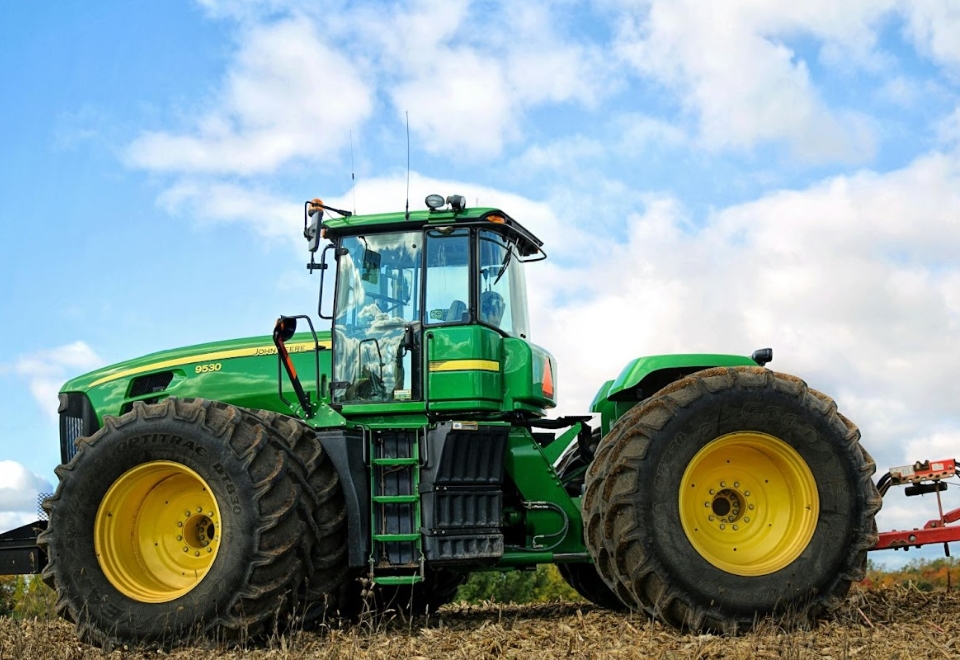 Large green tractor on farmland, symbolising the role of equipment finance for Australian farmers.