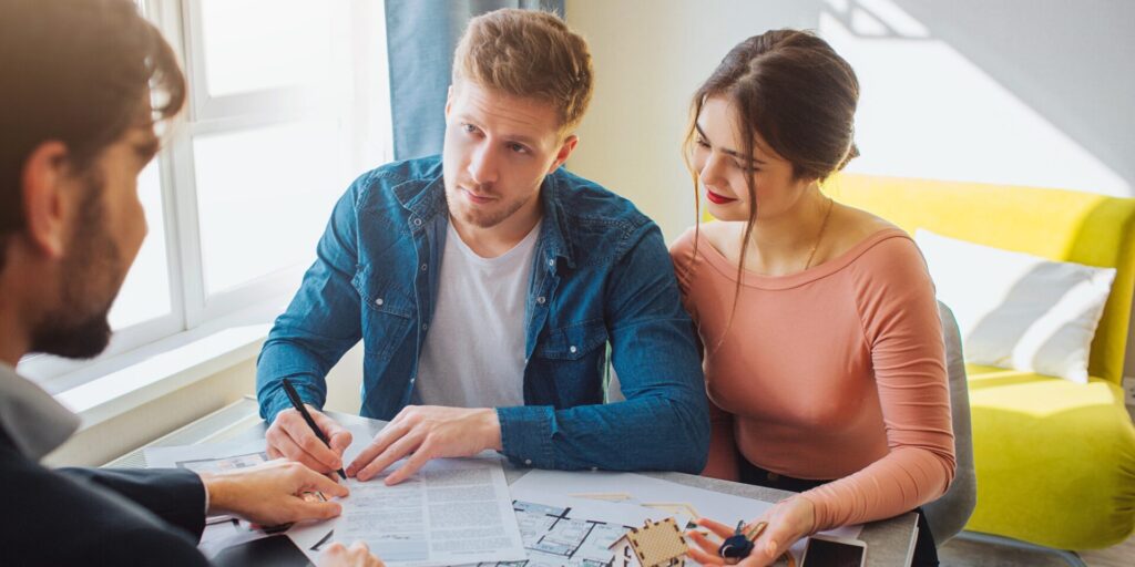 Young couple meeting with a financial adviser, reviewing documents and discussing home loan and offset account options.